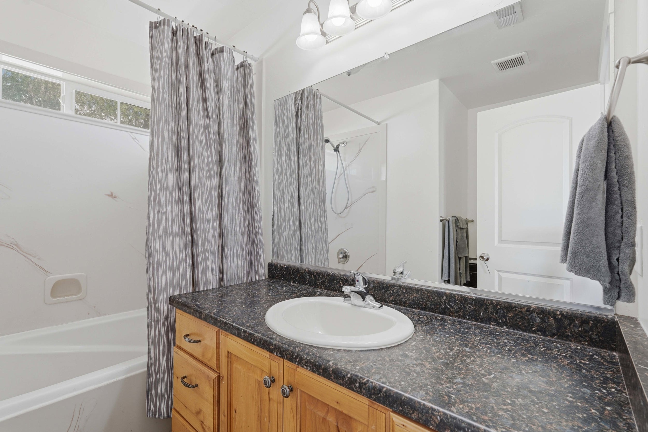 Full bathroom with shower / bath combination with curtain and vanity