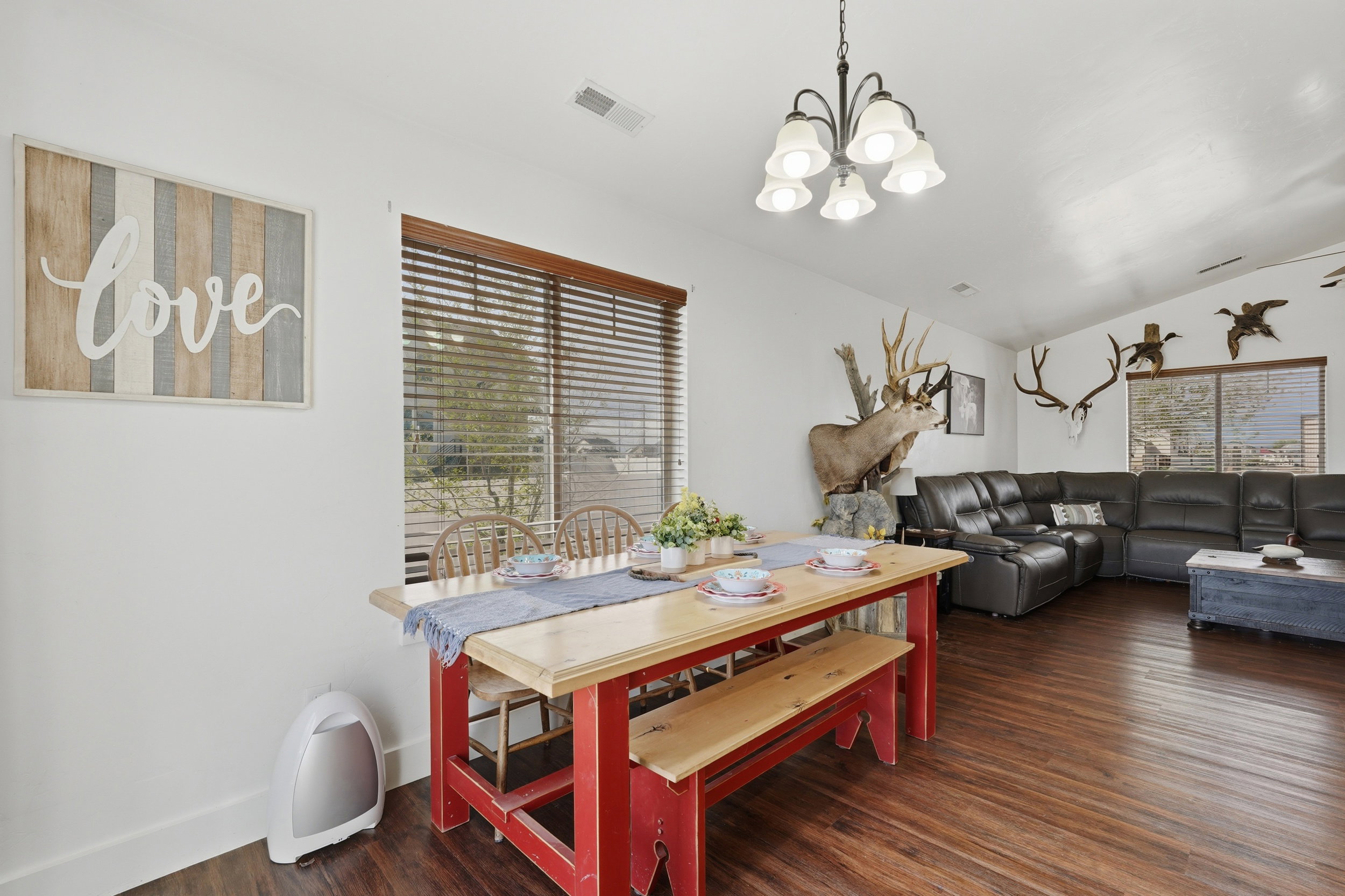Dining space with dark wood-style floors, vaulted ceiling, and a chandelier