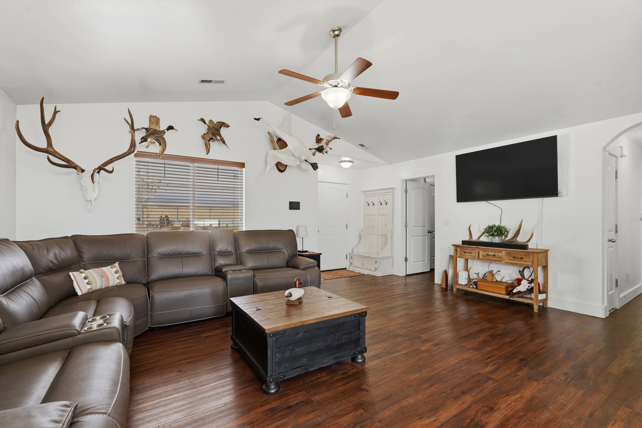 Living room featuring wood finished floors, arched walkways, and ceiling fan