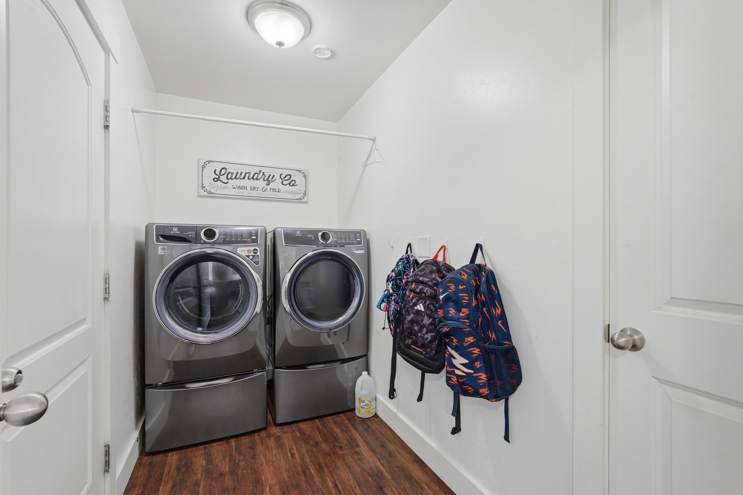 Laundry area with dark wood-style floors and washer and clothes dryer