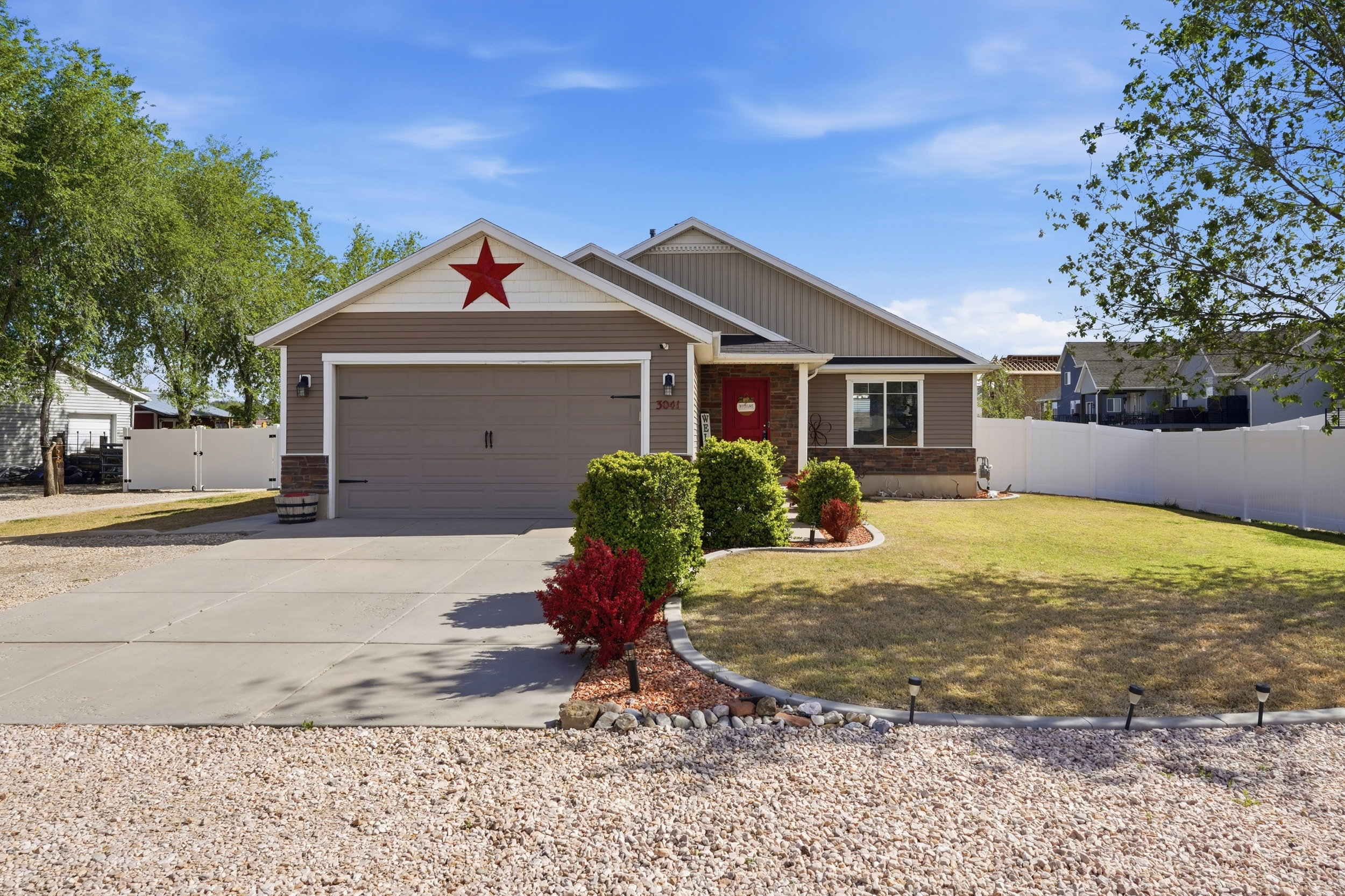 View of front of home featuring driveway, a gate, and a garage