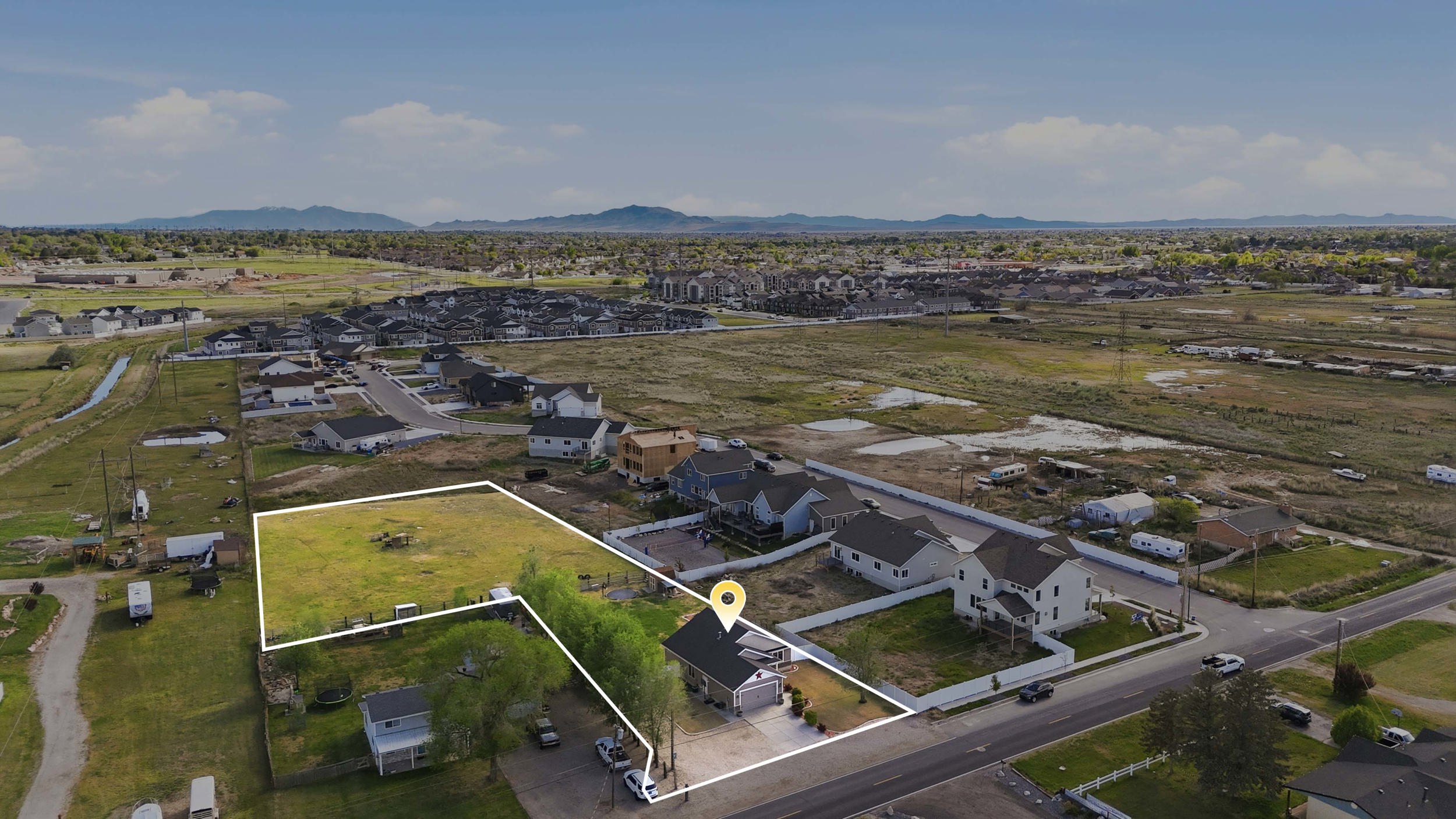Aerial perspective of suburban area featuring property parcel outlined and a mountain backdrop