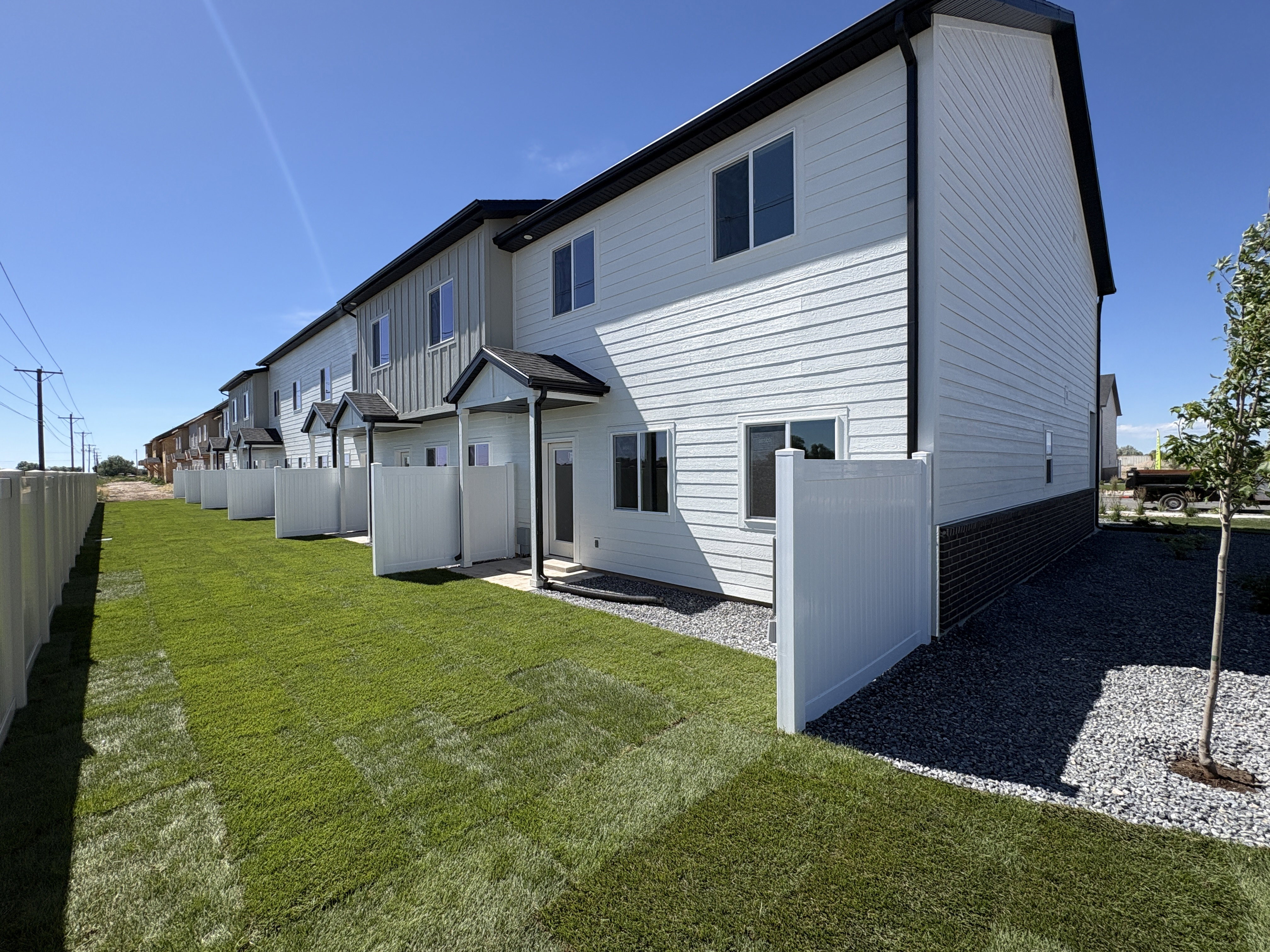 Contemporary townhome exterior featuring light-colored siding with dark trim accents
