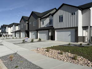 View of property exterior with a residential view, board and batten siding, brick siding, and a garage