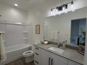 Full bathroom with vanity, dark wood finished floors, shower / tub combination, and recessed lighting