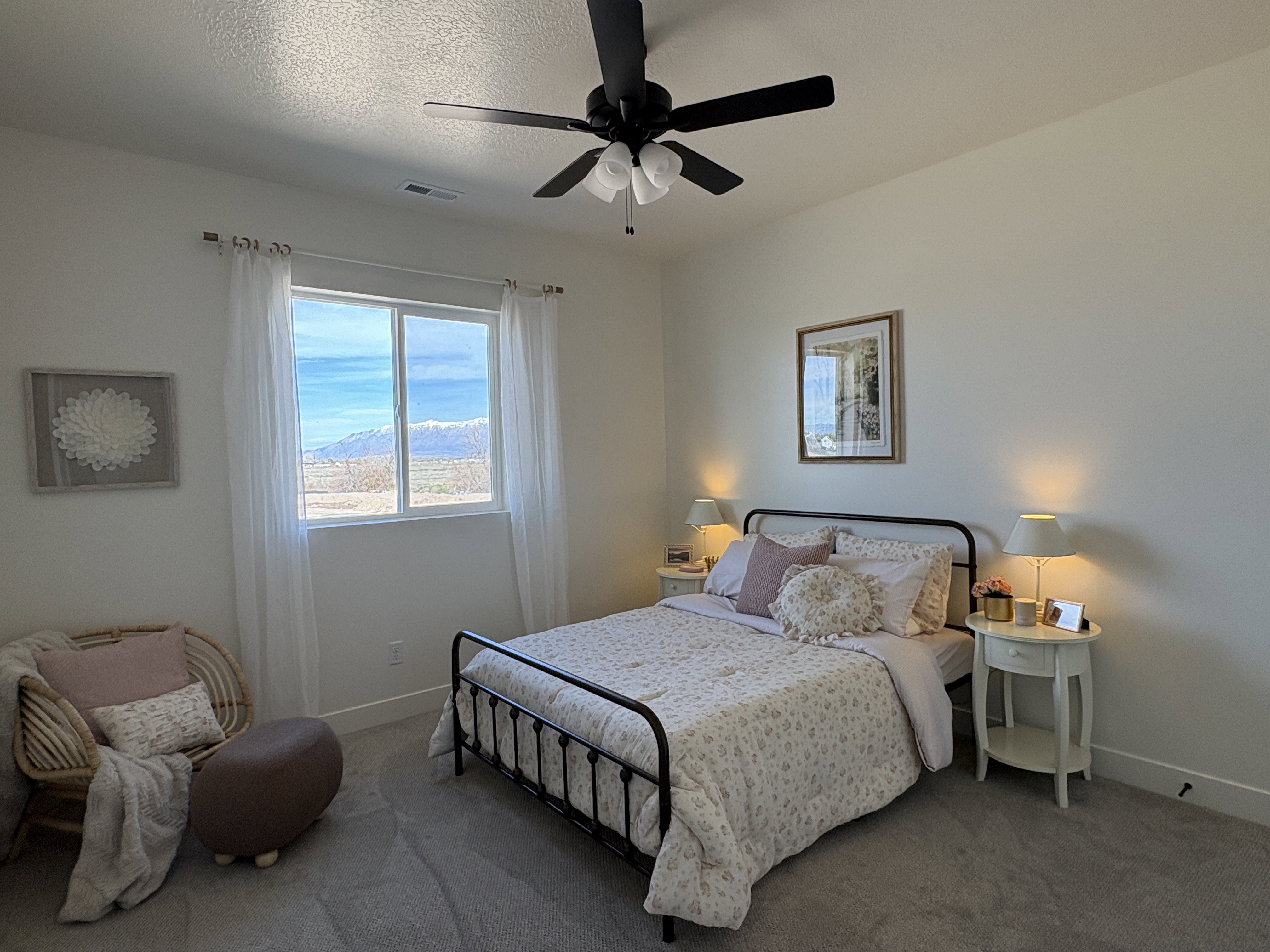Carpeted bedroom with a ceiling fan and a textured ceiling
