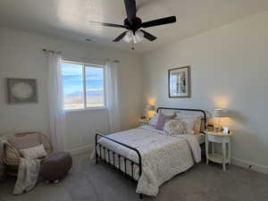 Carpeted bedroom with a ceiling fan and a textured ceiling