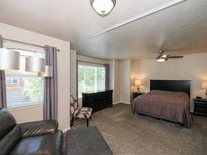 Spacious room featuring carpeting, multiple windows with blinds, and a ceiling fan with integrated lighting