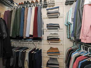 Custom closet system featuring multiple hanging rods, wire shelving, and overhead storage
