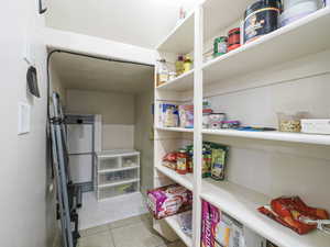 Built-in shelving providing extensive storage, tile flooring, and neutral wall finishes