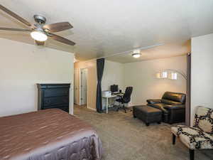 Carpeted room featuring a ceiling fan with integrated lighting, recessed lighting, and a built-in privacy partition