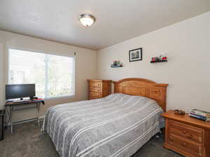 Spacious room featuring neutral wall tones, a large window with blinds, and recessed lighting