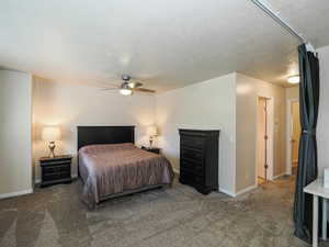Carpeted interior space featuring a ceiling fan with integrated lighting, neutral wall tones, and white baseboards