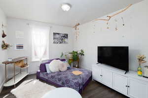 Family room with dark wood finished floors, arched walkways and lots of natural light.