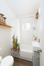 Full bath featuring vanity, dark wood-type flooring, and shower / tub combo with shower curtain.