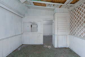 Workshop / storage area in exterior building featuring unfinished concrete floors.
