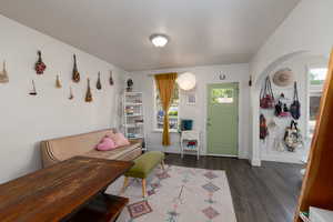 Living room with arched walkways and dark wood finished floors