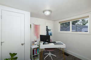 Bedroom used as home office featuring dark wood finished floors.