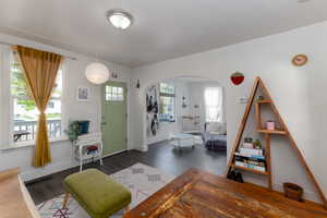 Family room with dark wood finished floors, arched walkways and lots of natural light.