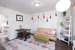 Living room with arched walkways and dark wood finished floors