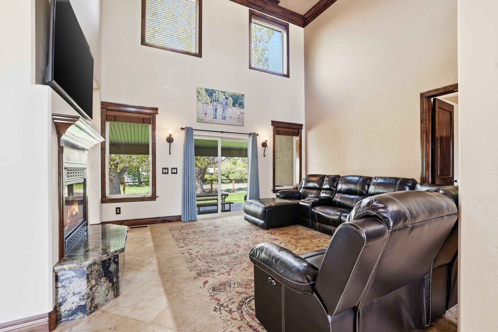 Living area featuring high vaulted ceilings with wood trim accents and a fireplace with a stone hearth