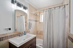 Full bathroom with vanity and shower / bathtub combination with curtain