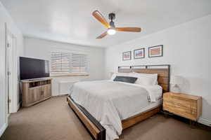 Carpeted bedroom with ceiling fan and baseboards