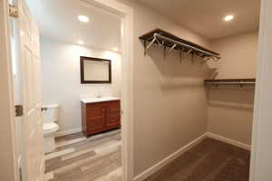 Walk in closet with light wood-style floors