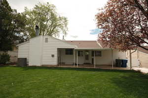 Rear view of house featuring a patio area, a chimney, and roof with shingles