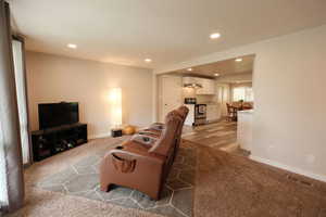 Living area featuring light colored carpet and recessed lighting