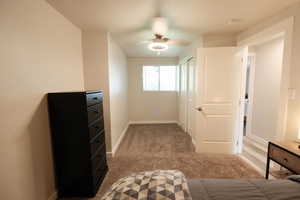 Unfurnished bedroom with light colored carpet, ceiling fan, and a closet
