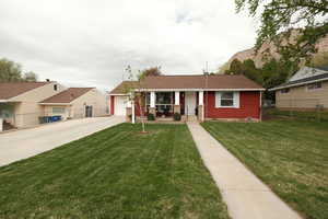 View of front facade featuring covered porch, driveway, and an attached garage