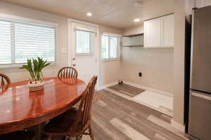 Dining room with light wood-style floors and recessed lighting