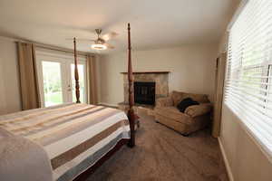 Bedroom featuring ceiling fan, access to outside, dark colored carpet, and multiple windows
