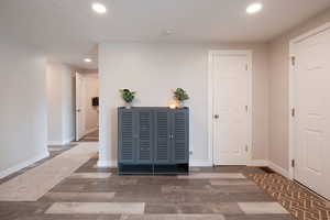 Entrance foyer with wood finished floors and recessed lighting