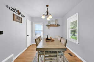 Dining room featuring suspended lighting and light wood finished floors