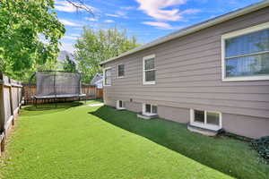 Fenced backyard with a trampoline