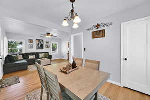 Dining area featuring suspended lighting, light wood-type flooring, and a ceiling fan