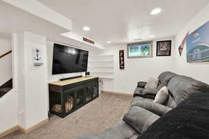Living area with light colored carpet and recessed lighting