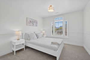 Bedroom featuring light carpet and baseboards