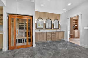 Bathroom featuring double vanity, a sauna / steam room, a walk in closet, and recessed lighting