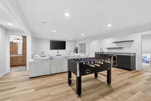 Game room with light wood-type flooring and recessed lighting