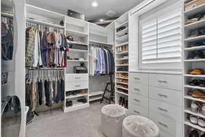 Walk in closet with light carpet