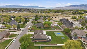 Aerial view of property and surrounding area with nearby suburban area and a mountain backdrop