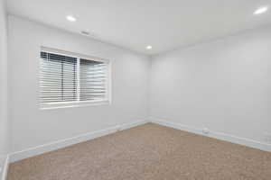 Carpeted empty room featuring baseboards and recessed lighting