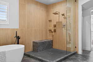 Bathroom with a shower stall and a freestanding tub