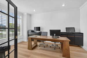 Office space featuring light wood-style floors, recessed lighting, ornamental molding, and a textured ceiling