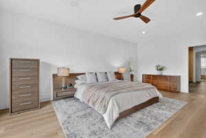 Bedroom with light wood finished floors, a ceiling fan, and recessed lighting