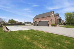 View of home's exterior featuring brick siding, a yard, roof with shingles, concrete driveway, and an attached garage