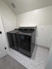 Laundry room with washer and clothes dryer and a textured ceiling